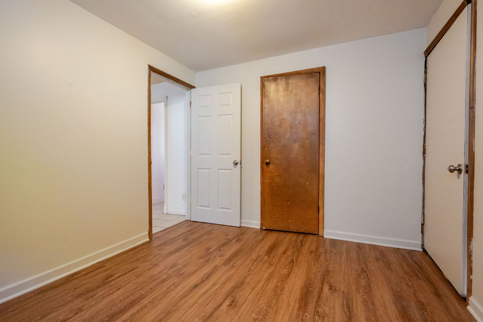 Bedroom with wood-look flooring, toward the hall