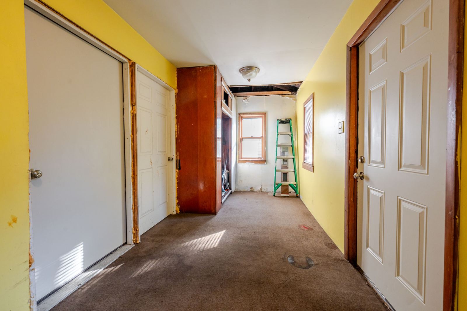 Rear room with yellow walls and dark carpet